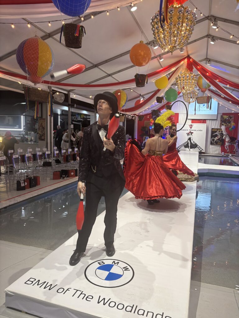 Jugglers and can-can dancers performed on the runway before the fashion show start at the Roemer home. (Photo by Laura Landsbaum)