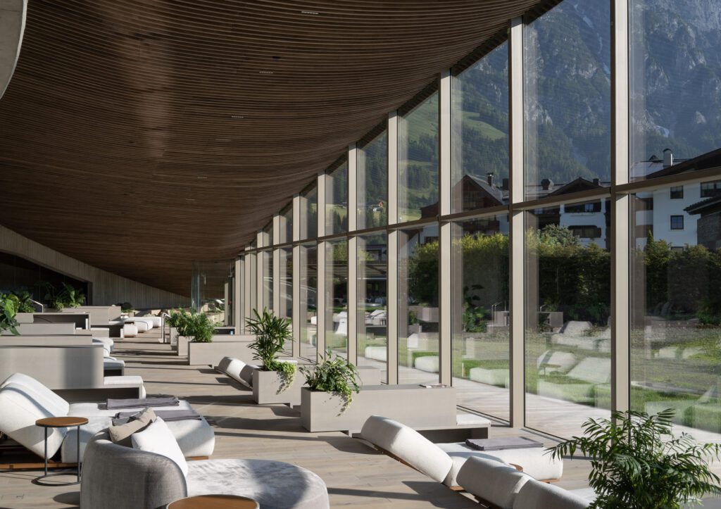 Guests sip herbal elixirs and biodynamic wines in their robes while soaking in panoramic views of the Austrian Alps.
