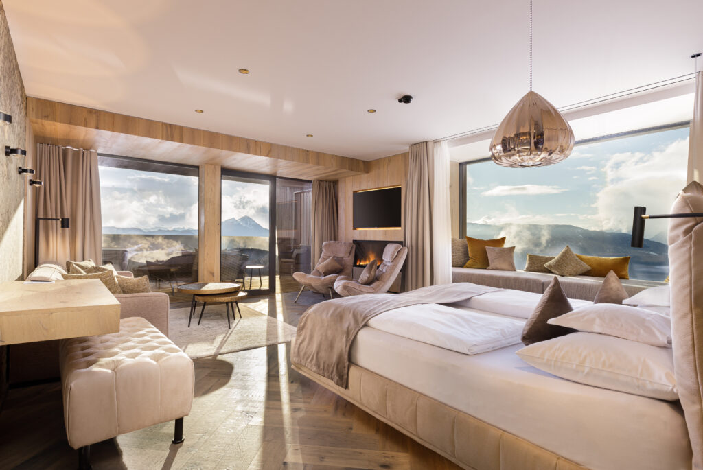 Inside the luxury suites, warm fireplaces, natural wood tones, and soft textiles create a modern mountain-chic retreat in the heart of northern Italy.