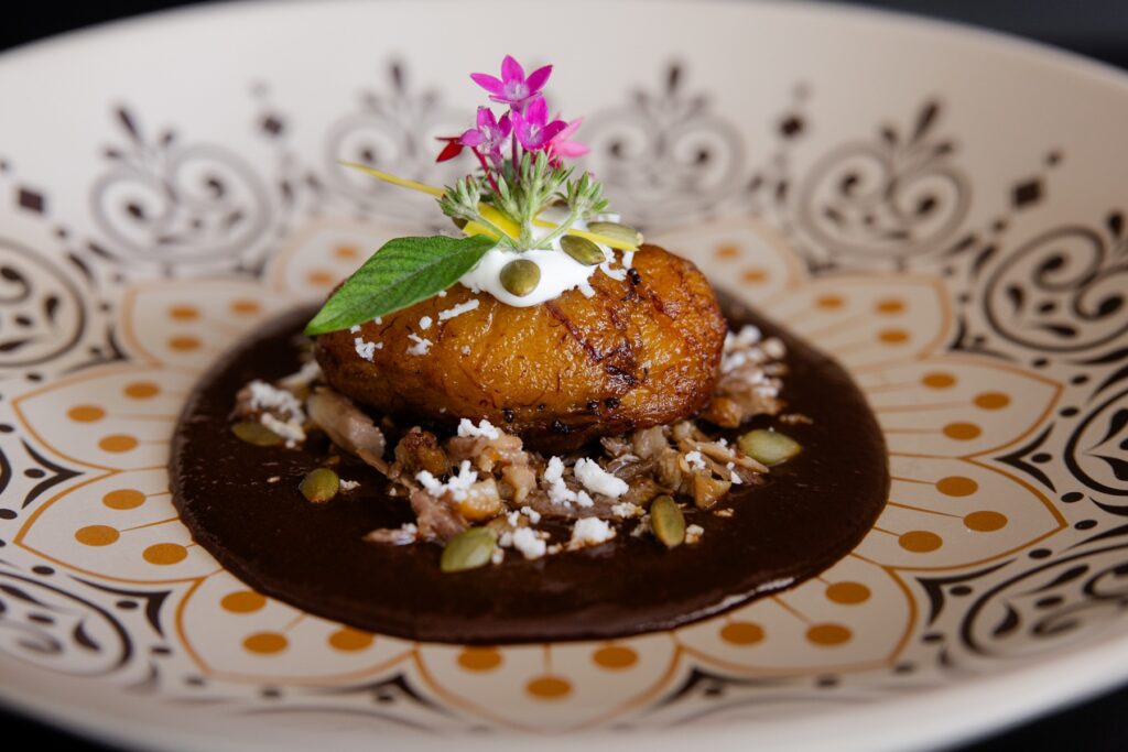 The Molete is a plantain and duck confit empanada in Qaxaca mole, with sesame and pepitas served at The Houstonian Ciggaros & Smoke dinner