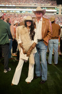 Cotton Holdings Chief Marketing Officer Zinat Ahmed with Founder and Chairman Pete Bell on the sideline of the 2025 Lone Star Showdown; photo courtesy of Cotton Holdings