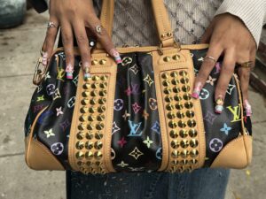 Louis Vuitton Monogram Multicolor Courtney MM handbag. This limited-edition, collectible bag was part of an iconic collaboration between artist Takashi Murakami and Louis Vuitton, first introduced in 2003, and is typical of the luxury handbags shoppers might discover at 2nd Street USA.