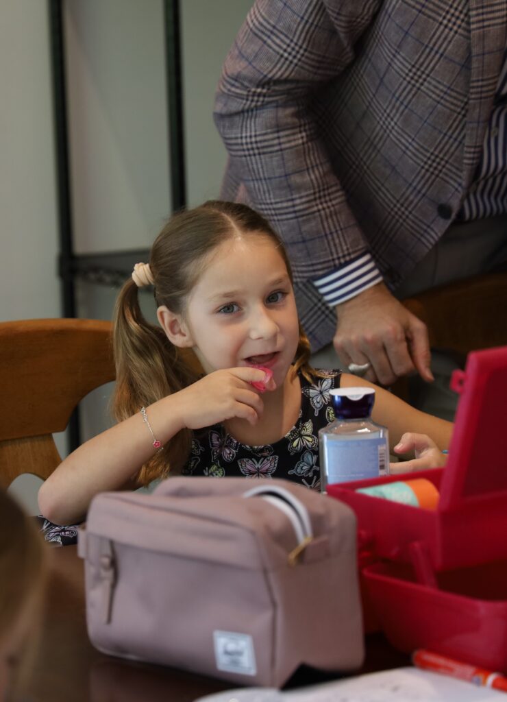 During the sessions, the students learn grooming techniques and Anabel is applying lip balm from her Beauty Box. 