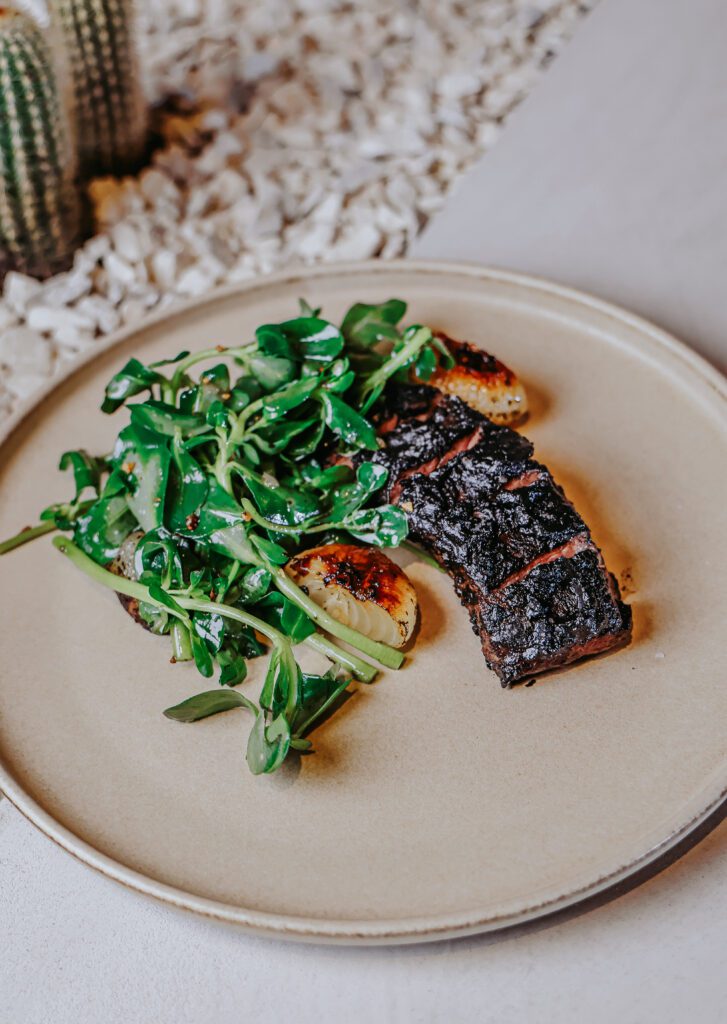 For entrees, the wagyu bavette is a solid choice with cauliflower, purslane, and recado negro bast. (Photo by Puerto Cocina & Bar/Jhair Guzmán)