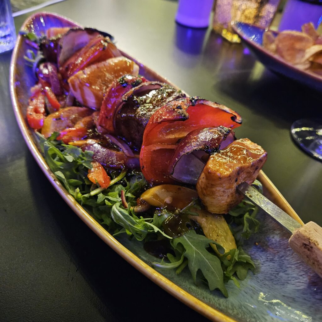 The Monster Kabob at Brooklyn's comes with generous portions of steak, chicken, and pineapple set over a bed of arugula and roasted vegetables. (Courtesy)
