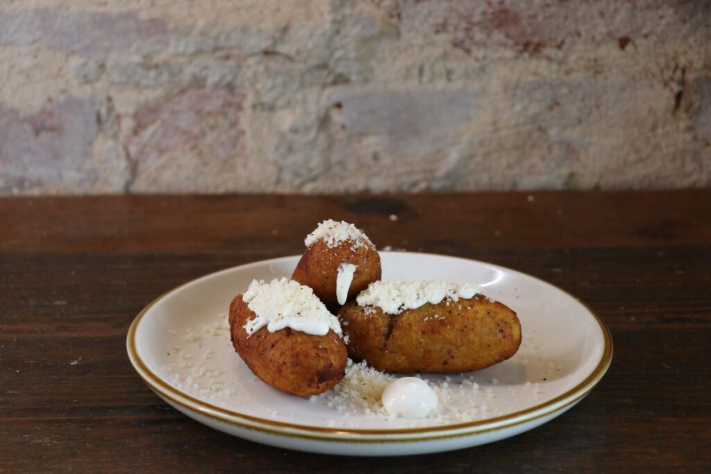 The molotitos de plátano y queso seco look like little corn dogs but are made using a mashed plantain dough that is fried until golden. (Photo by Burciaga Hospitality Group)