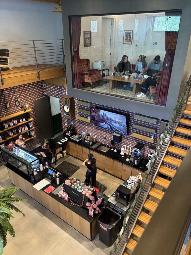 A room at the top has a glass panel, allowing a full view of the two level coffee shop.