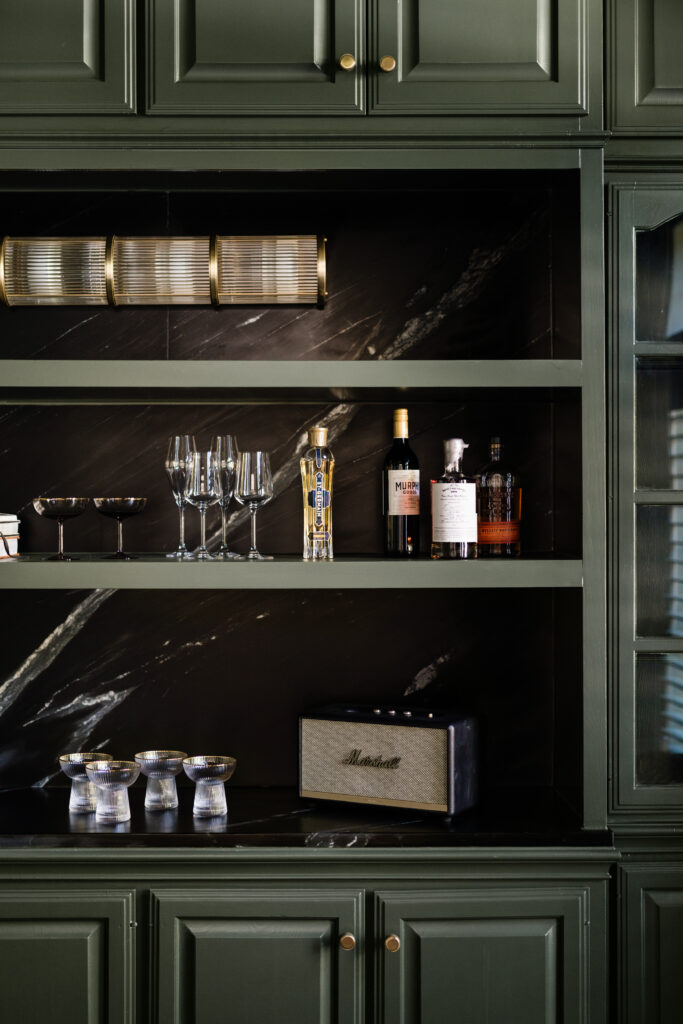 Cabinet doors were removed to create open shelving and a bar area in the office of this reimagined Palmer Woods home. (Photo by Madeleine Harper Photography)