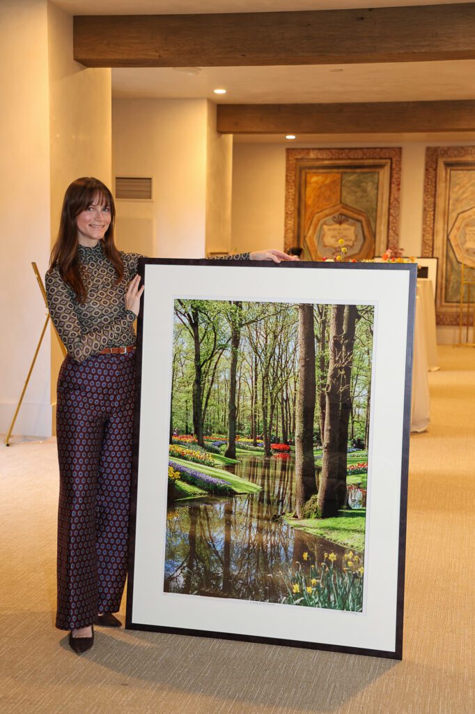 Photographer Christiana Reckling  with 'A Tapestry of Water and Wood' at her debut photography show, held at Hotel Granduca (Photo by Mia Bonner Photography)