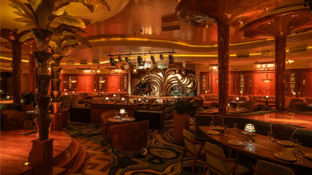 A large main stage is adorned with "Austrian curtains, plus three dedicated performance platforms surrounded by Delilah’s iconic golden palm trees for a larger-than-life experience." (Photo by Robert Tsai)