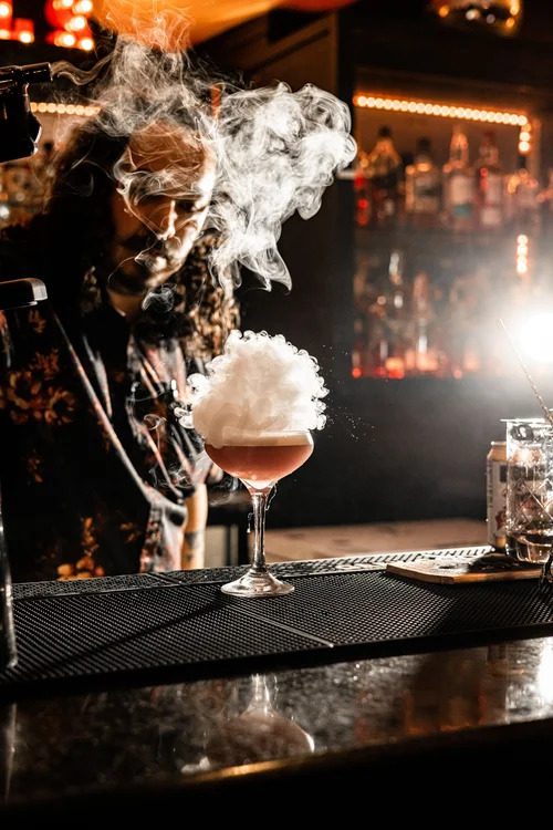 The underground dance club and bar features low ceilings, tufted booths, and neon accents that give Curfew the feel of a hidden basement lounge. (Courtesy)