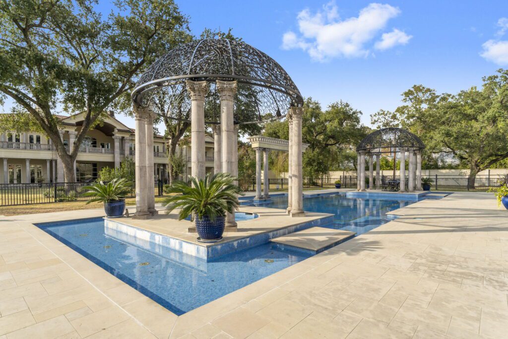 Two pergolas supported by Corinthian columns set this swimming pool at 6 W. Rivercrest apart from the ordinary (Photo by Iconic Images)