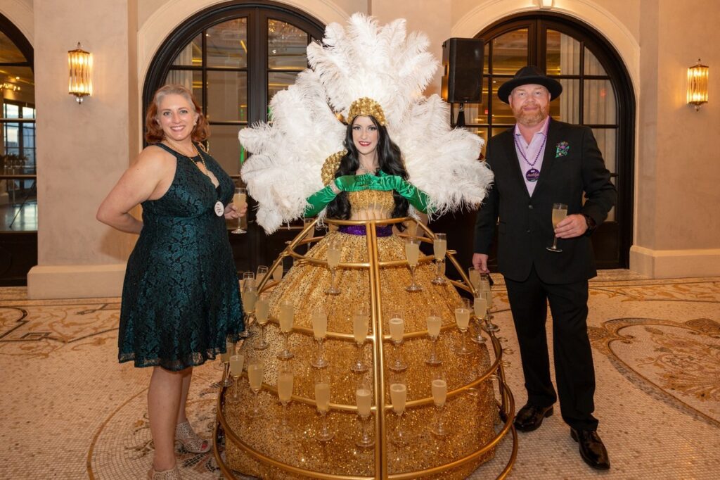 Allison & David Blair with the champagne skirt at LEAD's 6th Annual Mardi Gras Charity Event