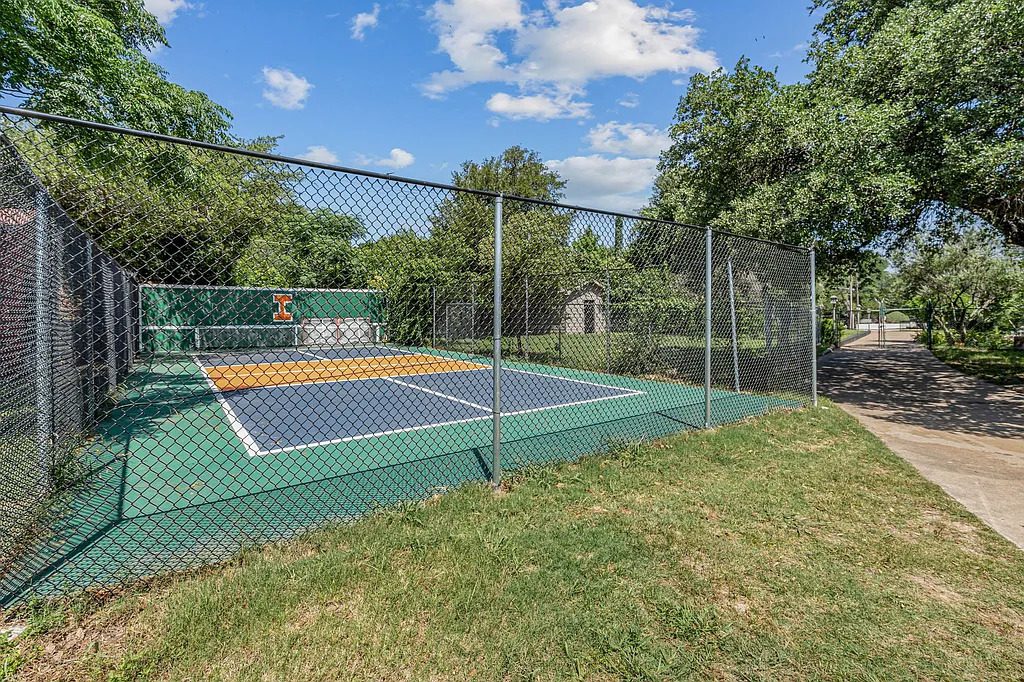 The fenced sports court at 4301 Briarhaven Road is tucked into the property’s greenery, offering a dedicated space for recreation beneath a canopy of mature trees. (Courtesy)