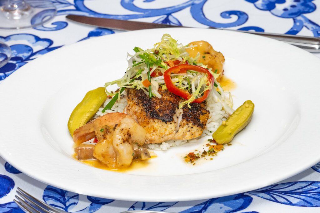 The main course — Blackened Redfish Henican with shrimp, tasso ham, and pickled okra — served at the 'Tribute to Louisiana Legends' dinner held at The Manor House at The Houstonian  (Photo by Jacob Power)