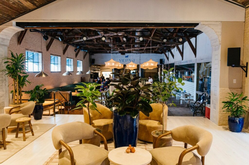 The transformed indoor dining room at Meraki now boasts a horseshoe bar near the entrance, hanging woven light fixtures throughout, overhead netting, and other light coastal touches. (Courtesy)