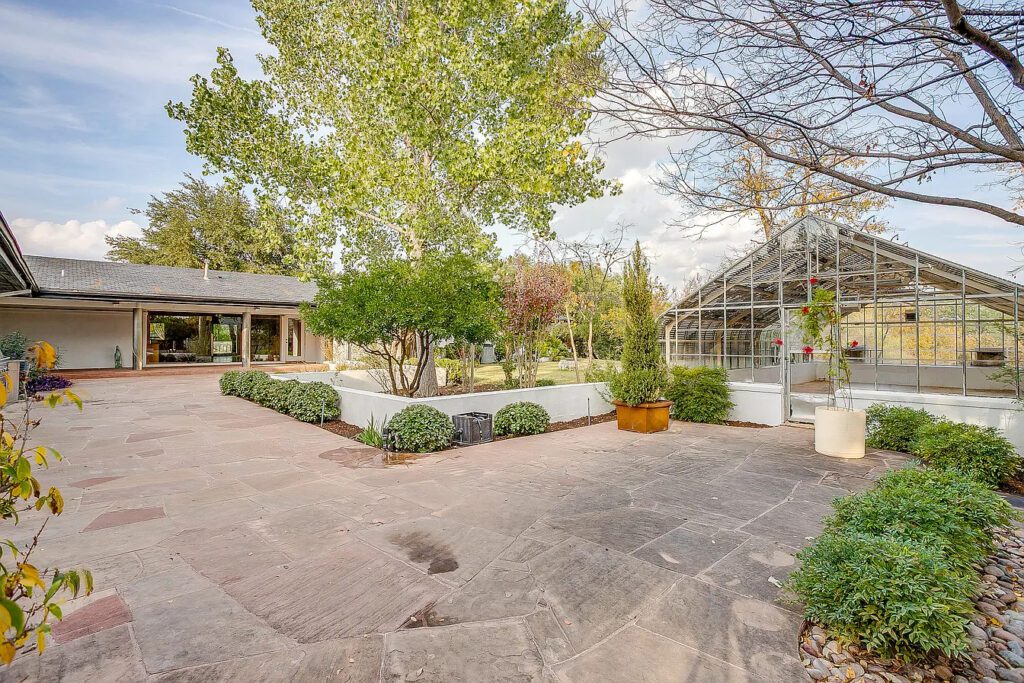 Two koi ponds sit within the landscape, alongside a sports court, greenhouse, and private well.