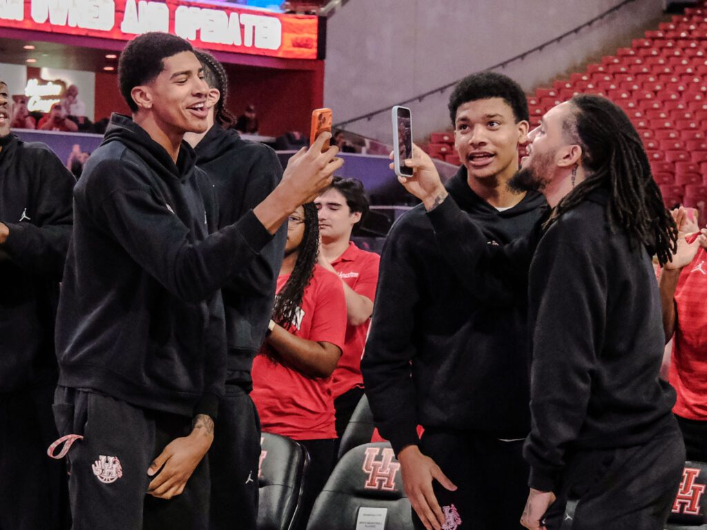 University of Houston freshman forward Chris Cenac Jr. and senior Emanuel Sharp  do dueling phones during the NCAA Tournament selection fun. (Photo by F. Carter Smith)