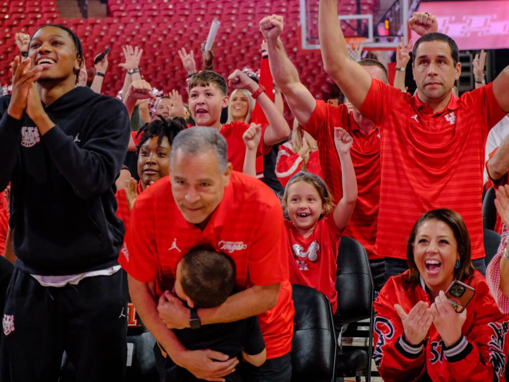 University of Houston coach Kelvin Sampson gave his grandson a big hug during the excitement of UH's NCAA Tournament reveal. (Photo by F. Carter Smith)