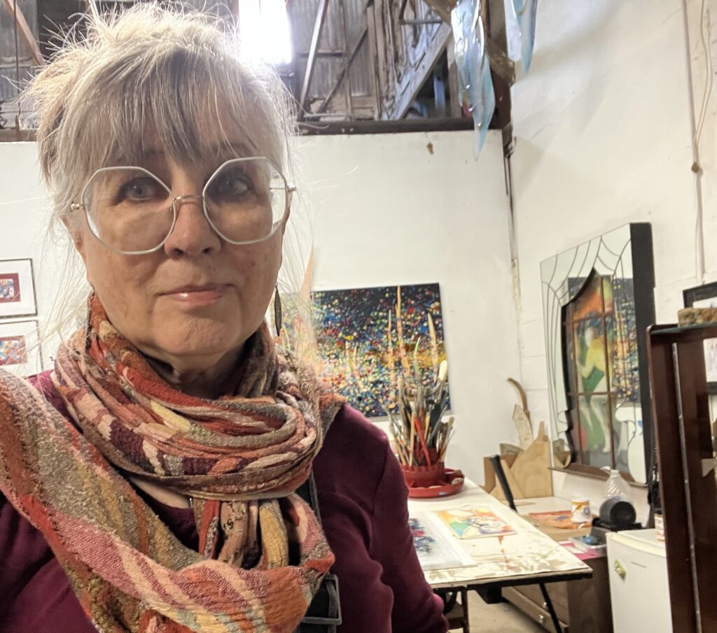 Artist Liz Conces Spencer frames herself alongside her work at Archway Gallery, where intricate patterns and measured compositions reflect a practice rooted in both discipline and exploration. (Photo courtesy Archway Gallery)