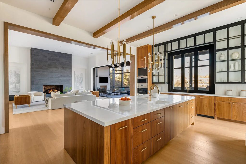 The kitchen features Sub-Zero, Wolf, and Miele appliances, all beneath Thomas O'Brien chandeliers. (Photo by Allie Beth Allman & Associates)