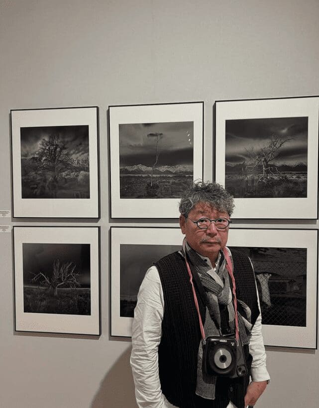 Osamu James Nakagawa stands with prints from his series "Witness Trees + Indelible Structures" during Paris Photo 2025 in Paris, France. (Photo courtesy Osamu James Nakagawa)