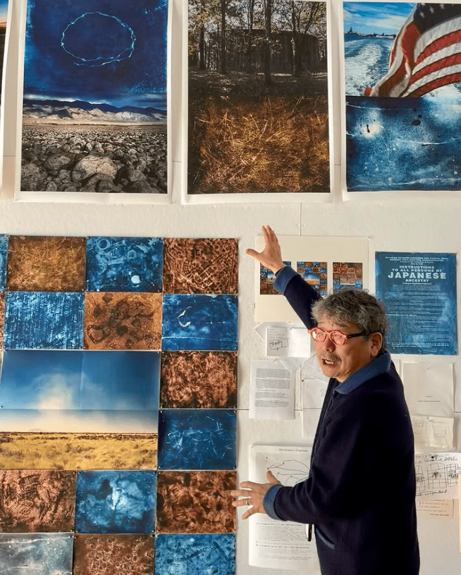 Osamu James Nakagawa discusses photographs from his projects exploring the landscapes of Japanese American incarceration during World War II in his studio. (Photo courtesy Osamu James Nakagawa)