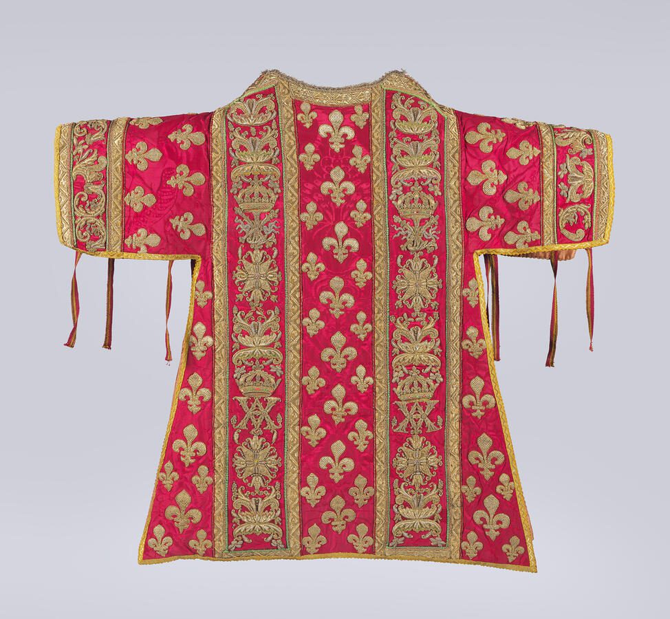 This crimson dalmatic from a 1619 vestment set commissioned under Louis XIII features dense gold embroidery and royal iconography woven into its design. Photo by Joseph Coscia Jr.