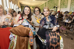 Fashionable ladies scoop up armloads of gently used/brand new clothing at the Salvation Army Auxiliary Reflections on Style luncheon