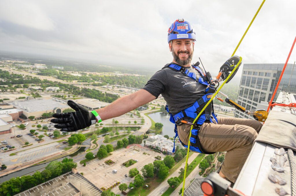 Camp For All participant Brandon Hinman of Howard Hughes Communities rappelled down The Woodlands Towers on The Woodlands Waterway on April 11. (Photo by Si Vo Photography)