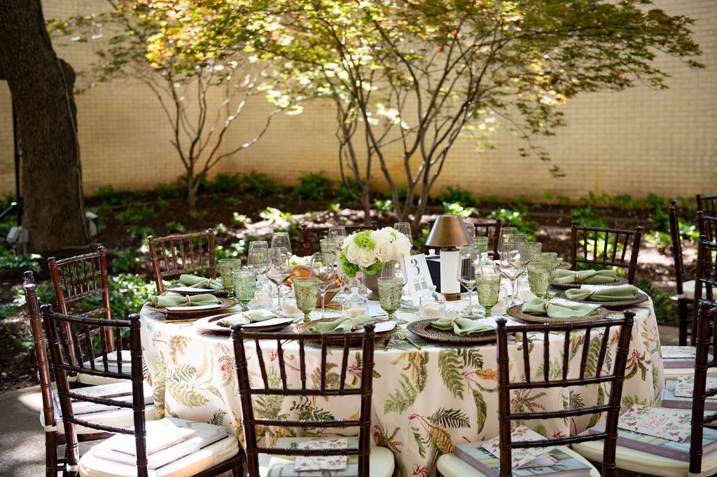 Dappled sunlight cast a magical glow across the garden, highlighting the beautifully set tables, which were adorned with rattan chargers and gorgeous “Les Fougeres” linens by Schumacher. (Photo by Tamytha Cameron Photography)