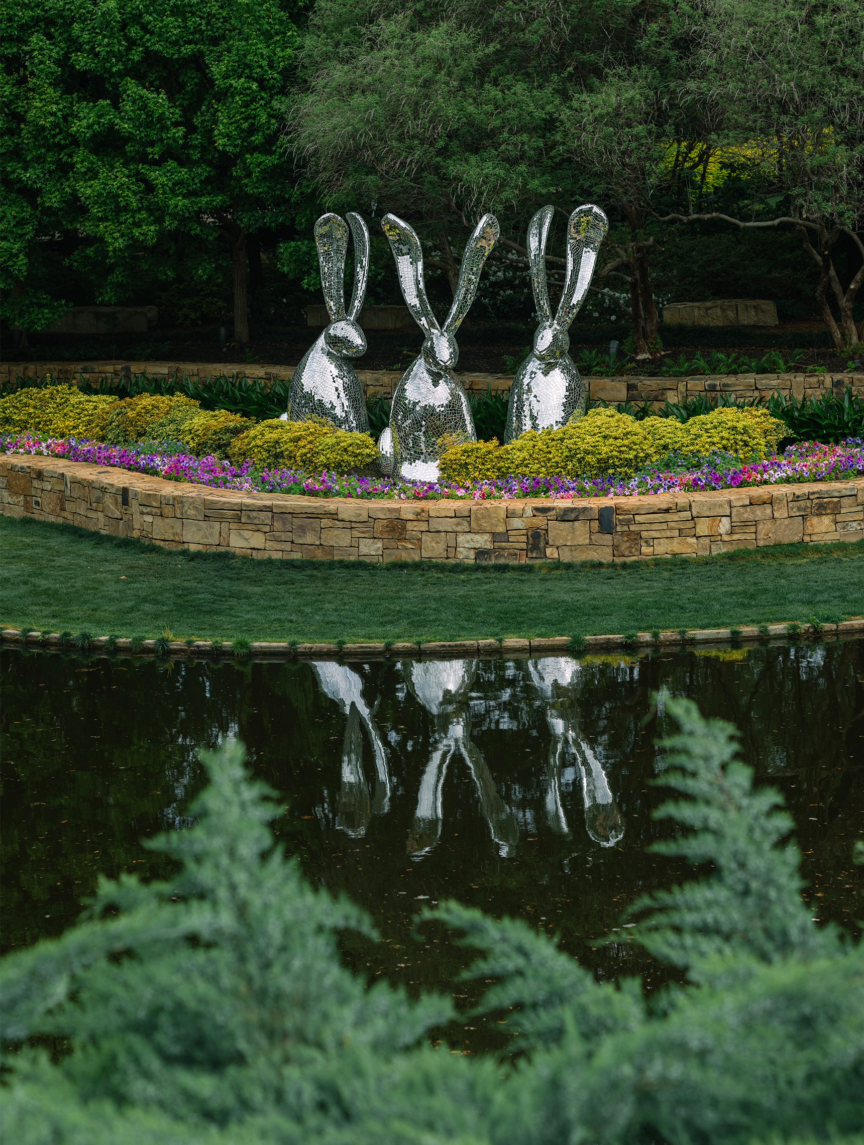 Three mirrored bunny sculptures in Dallas Arboretum garden