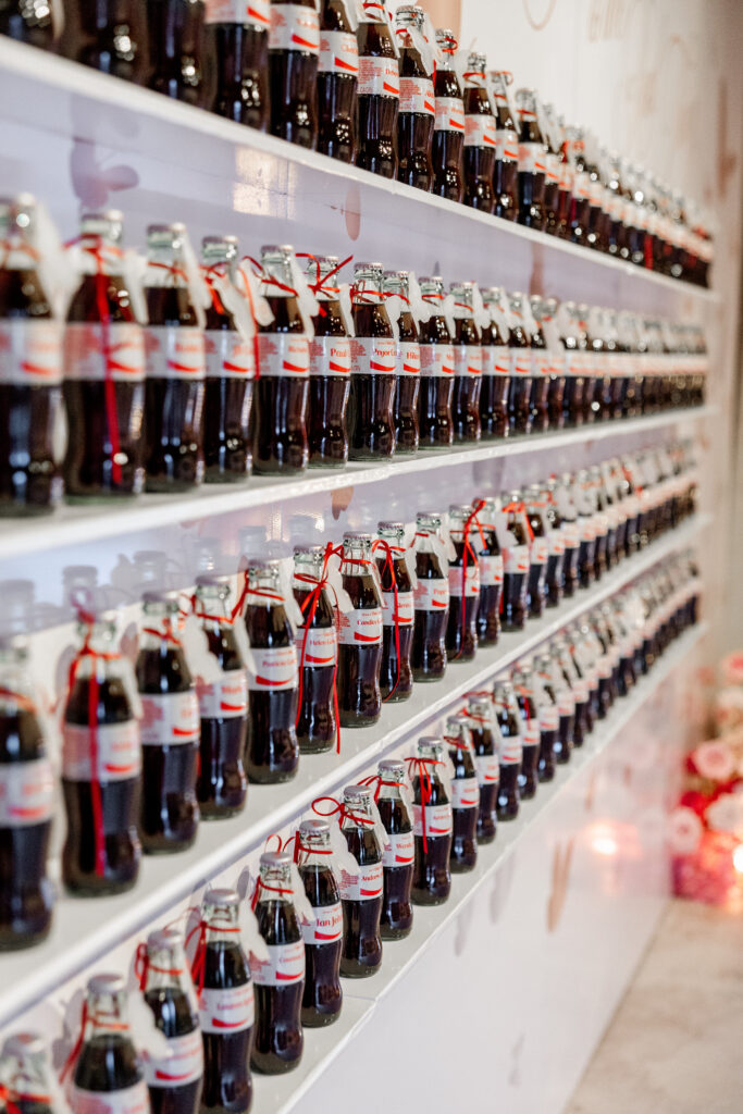 Glass bottle Diet Cokes custom-printed with each guest's name and table number served as the escort card. (Photo by Anastasiia Photography)