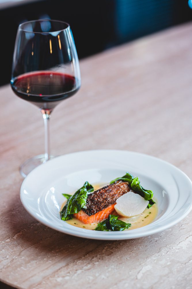 Ora king salmon poached in a citrus-tinged broth with spinach and turnips ($34) is served at Osteria di Mercato.