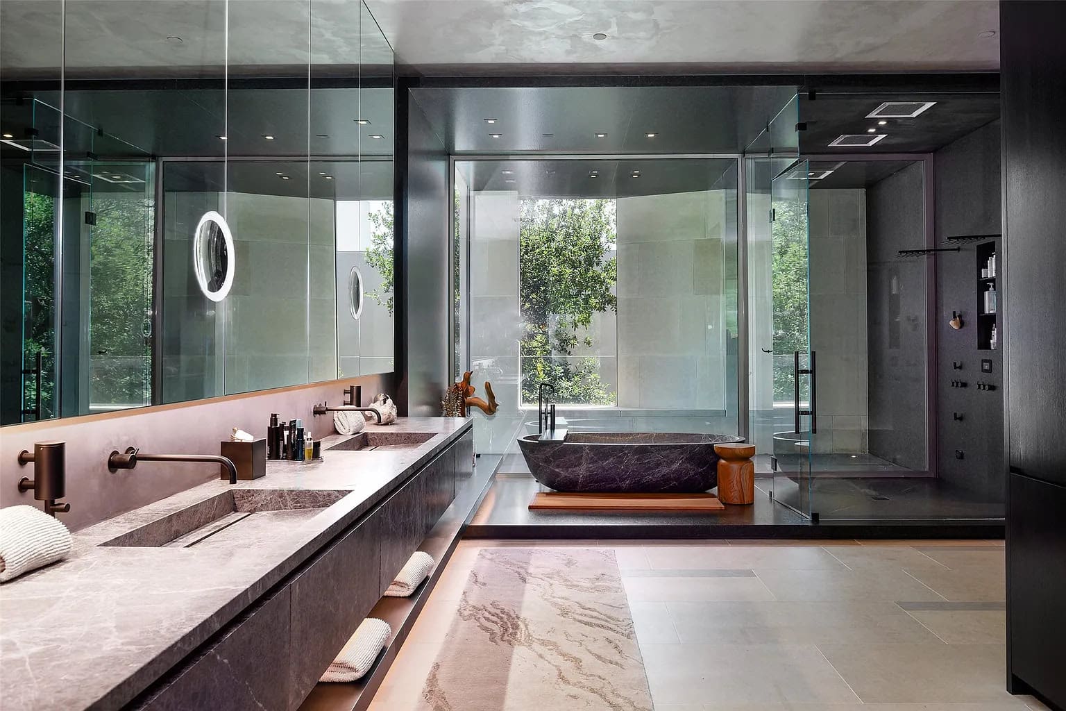 The primary suite features a freestanding soaking tub from a solid piece of stone, a fluted fireplace, and an oversized Poliform closet. (Photo by Stephen Reed Photography)