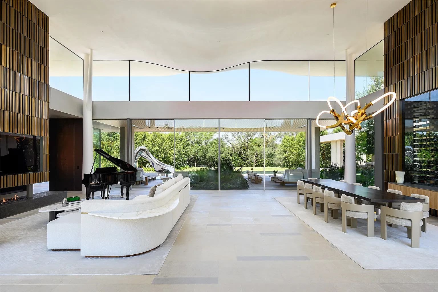 Past the lily pond, magnificent pivot doors open to a light-flooded glassy hallway and dramatic double-volume living space that immediately lets guests know, "Prepared to be dazzled." (Photo by Stephen Reed Photography)