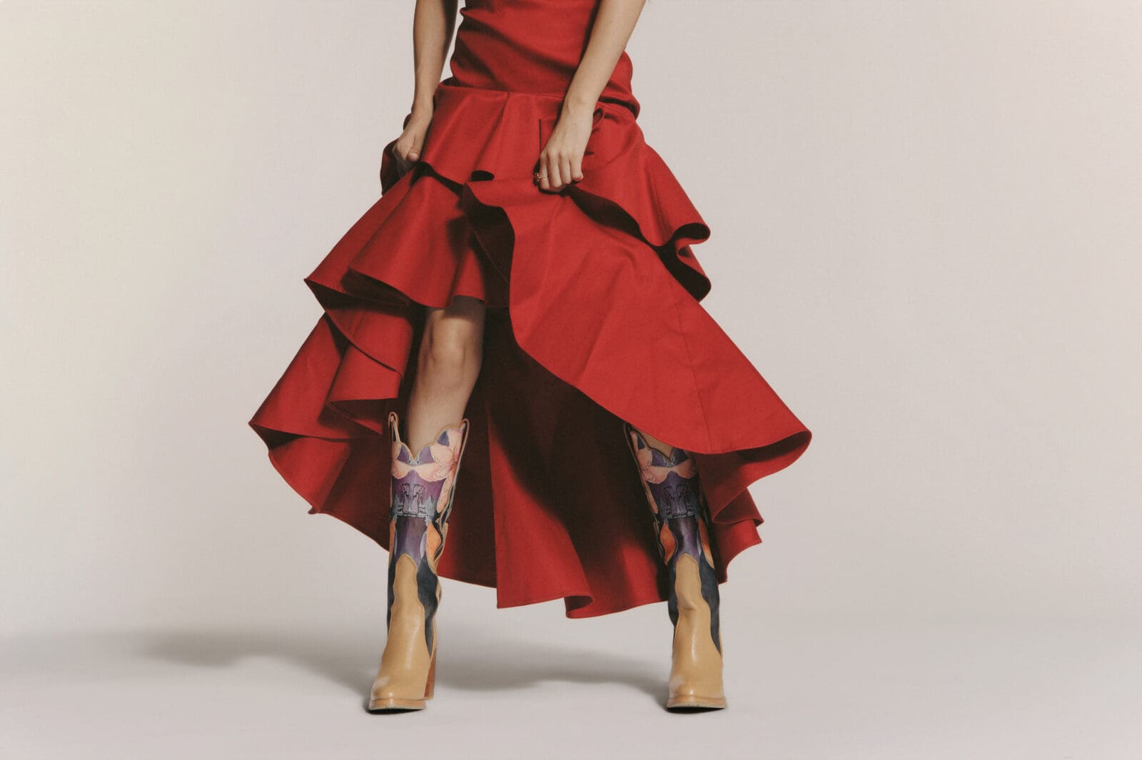 Step With Her features a sculptural boot with tan leather framing a rising backdrop of pink, purple, and green floral watercolors — a bold display of her mother’s artwork. (Photo by Nick Glover)