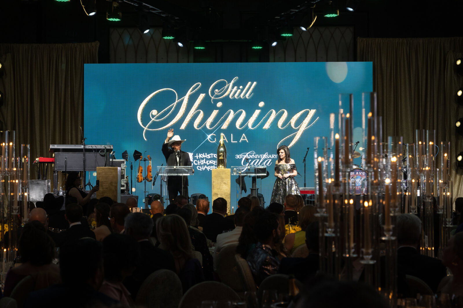 Tony Buzbee, Laura Ward on stage inviting bidders on accessible vans at Houston Children's Charity gala (Photo by Daniel Ortiz)